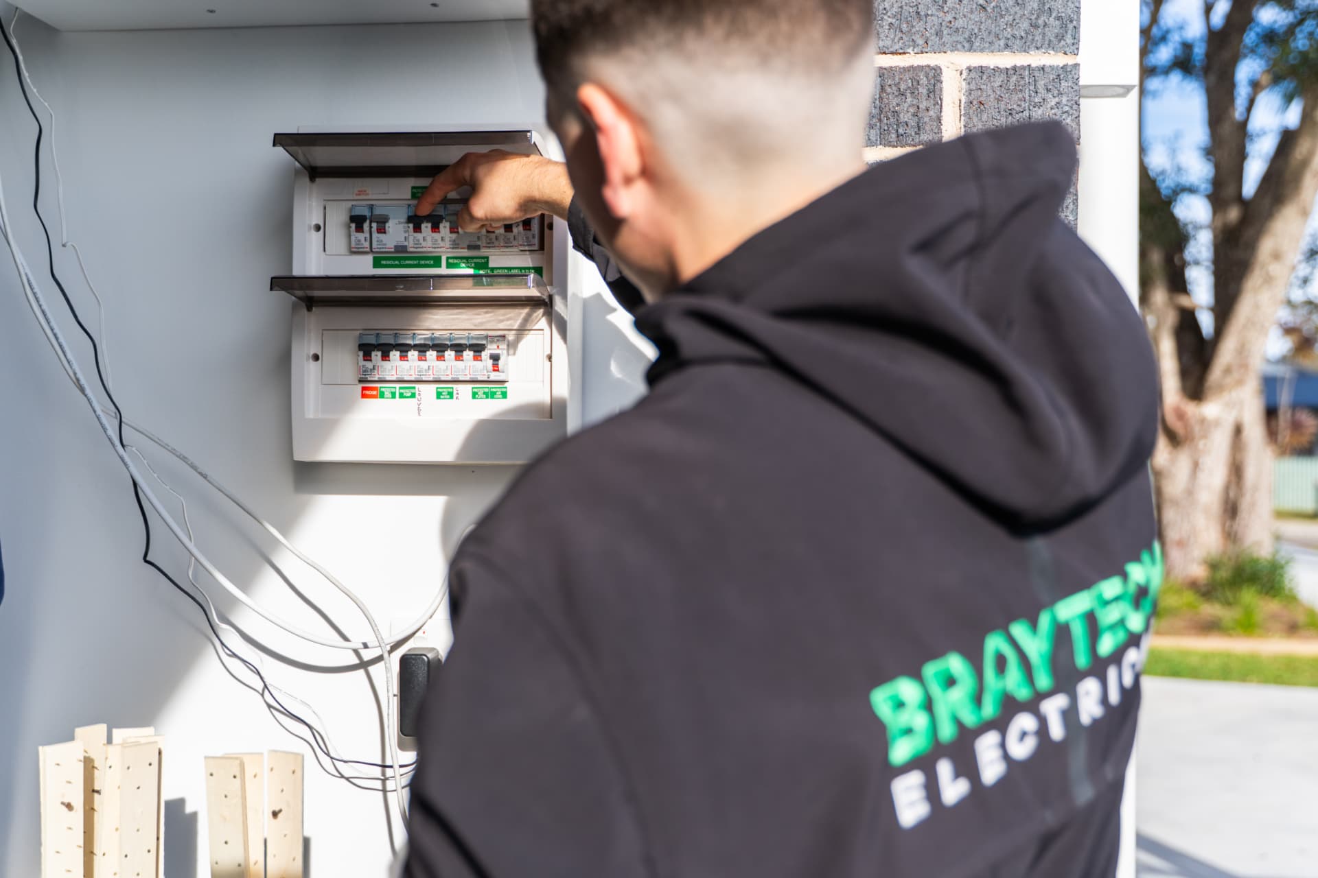 Electrician testing circuits at a residential switchboard